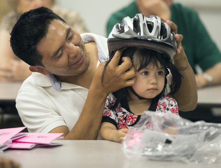 Dad fitting daughter with helmet