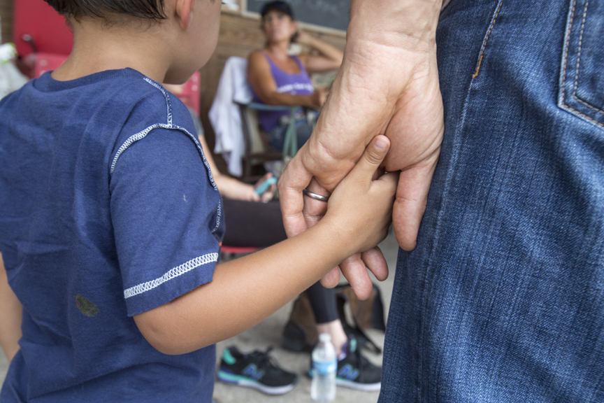 Father holding young son's hand