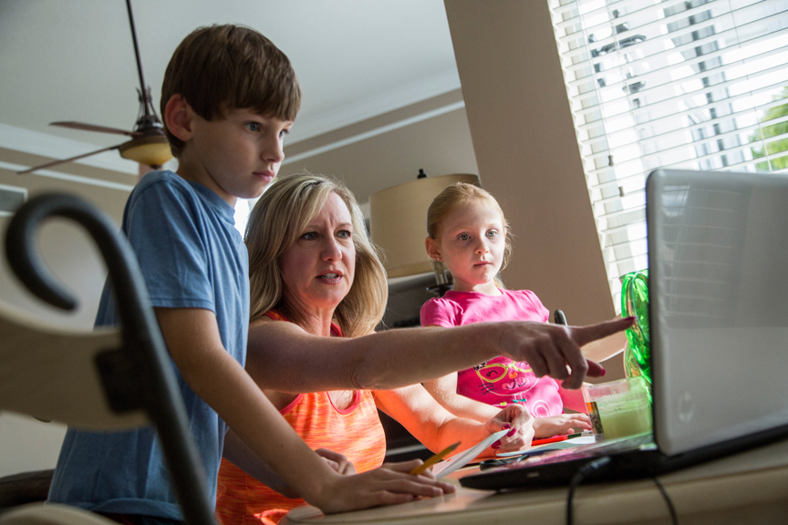 Mother showing son and daughter something on the computer