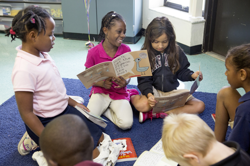 Children reading books to each other