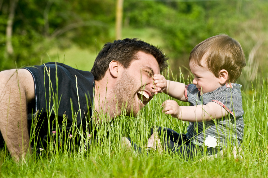 Father and young son playing in field