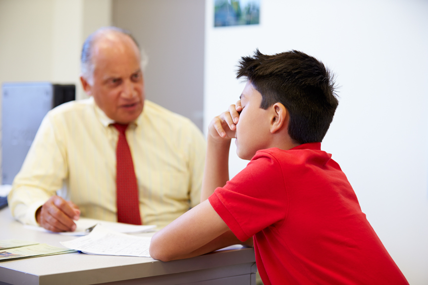 Boy looking stressed while talking with adult