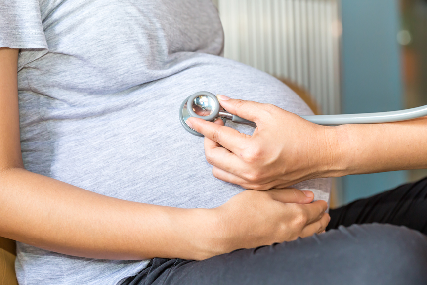 Doctor listening to pregnant woman's belly