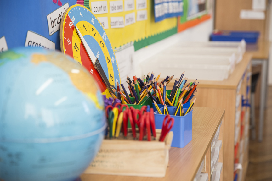 Classroom supplies including globe, scissors and colored pencils