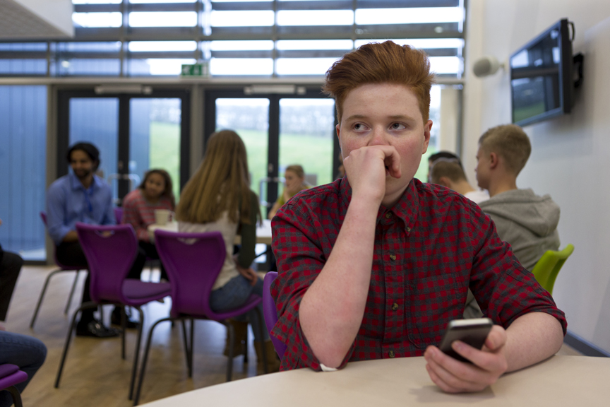 Teenager looking concerned holding phone