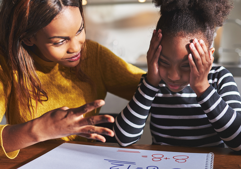 Woman helping young girl with homework