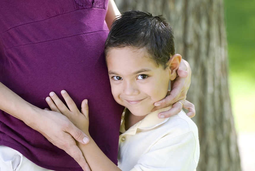 Boy hugging pregnant mother