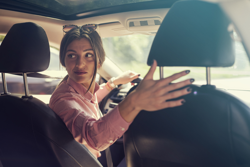 Women looking behind while backing up car